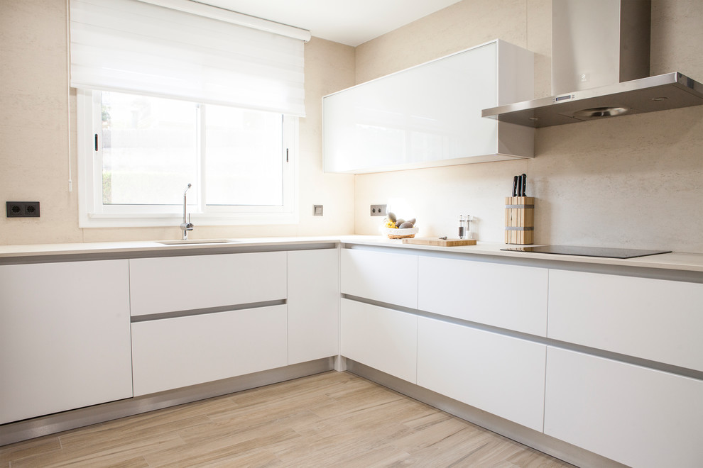 Foto de cocina contemporánea grande con armarios con paneles lisos, puertas de armario blancas y suelo de madera clara