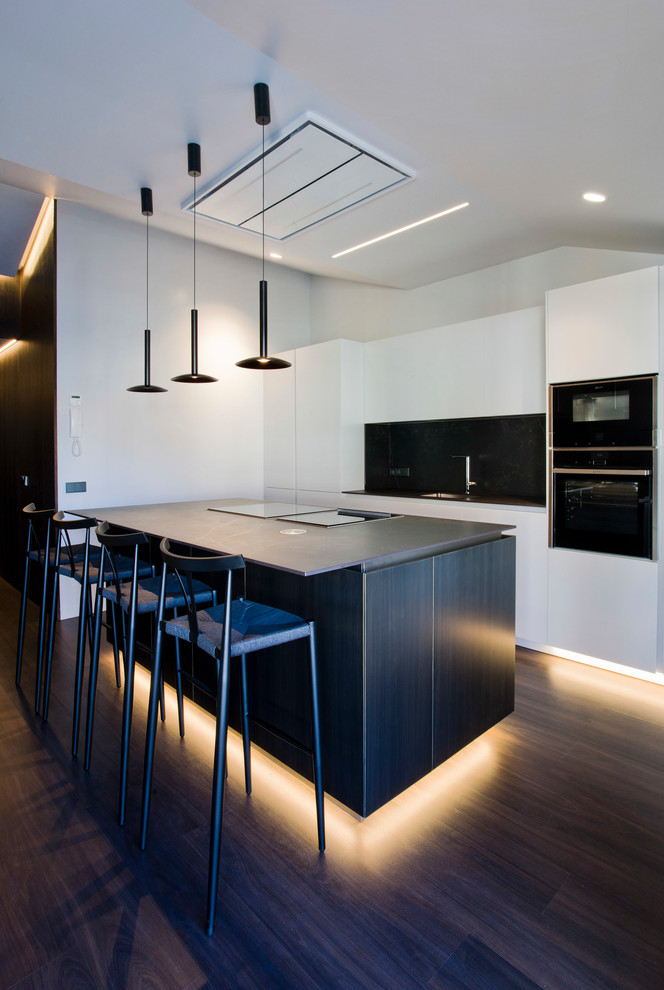 Imagen de cocina lineal minimalista grande abierta con armarios con paneles lisos y una isla