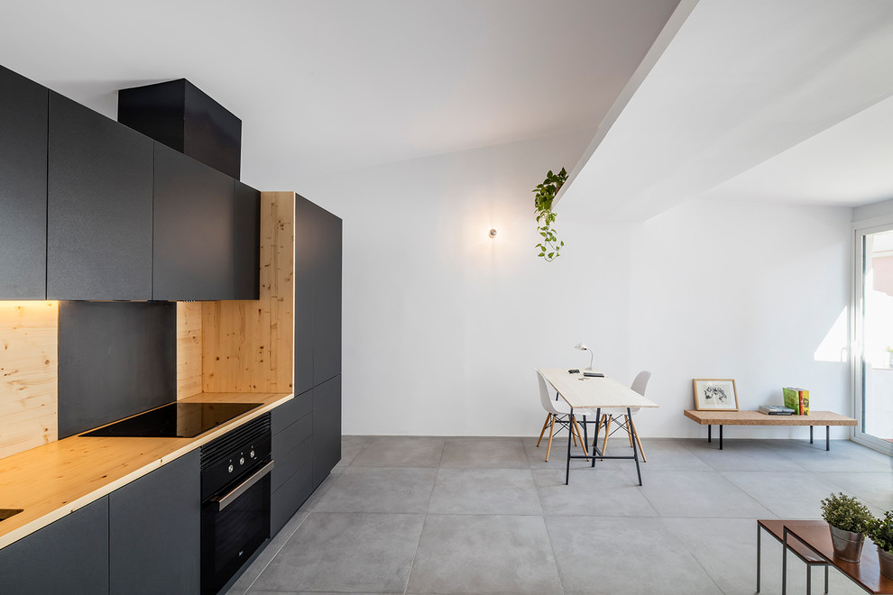 Inspiration for a medium sized contemporary single-wall open plan kitchen in Barcelona with a submerged sink, flat-panel cabinets, black cabinets, wood worktops, brown splashback, black appliances, ceramic flooring and no island.