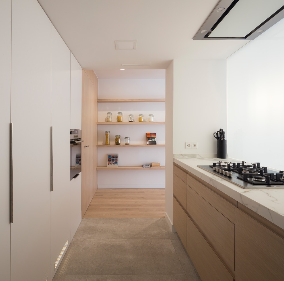 Bild på ett mellanstort minimalistiskt linjärt kök med öppen planlösning, med en undermonterad diskho, släta luckor, skåp i ljust trä, integrerade vitvaror, klinkergolv i keramik och en halv köksö
