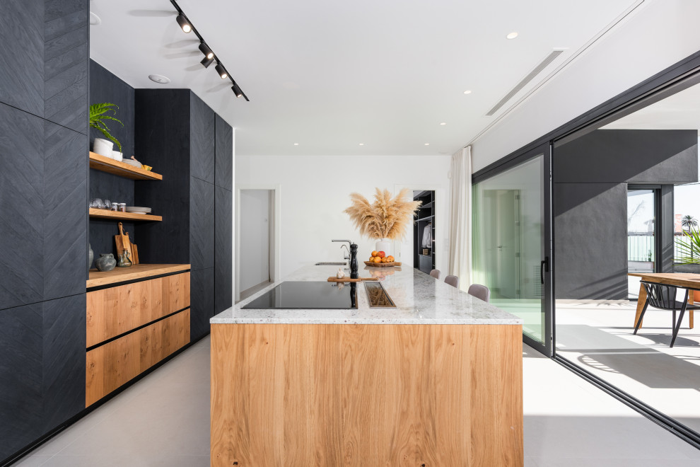 Expansive contemporary galley kitchen in Alicante-Costa Blanca with a submerged sink, flat-panel cabinets, black cabinets, wood worktops, integrated appliances, an island, grey floors and beige worktops.