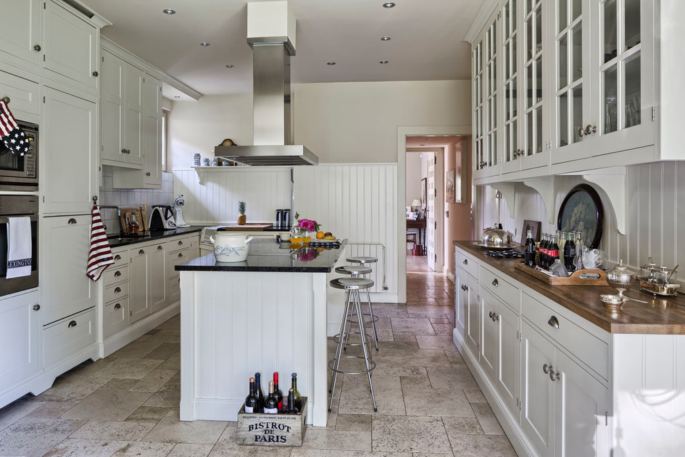 Inspiration for a large farmhouse galley enclosed kitchen remodel in Madrid with recessed-panel cabinets, white cabinets, white backsplash and an island