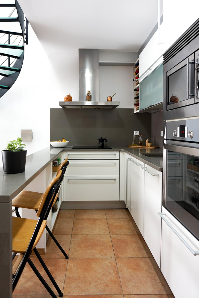 Eat-in kitchen - small contemporary l-shaped ceramic tile and orange floor eat-in kitchen idea in Barcelona with an undermount sink, flat-panel cabinets, white cabinets, quartz countertops, gray backsplash, marble backsplash, stainless steel appliances, gray countertops and a peninsula