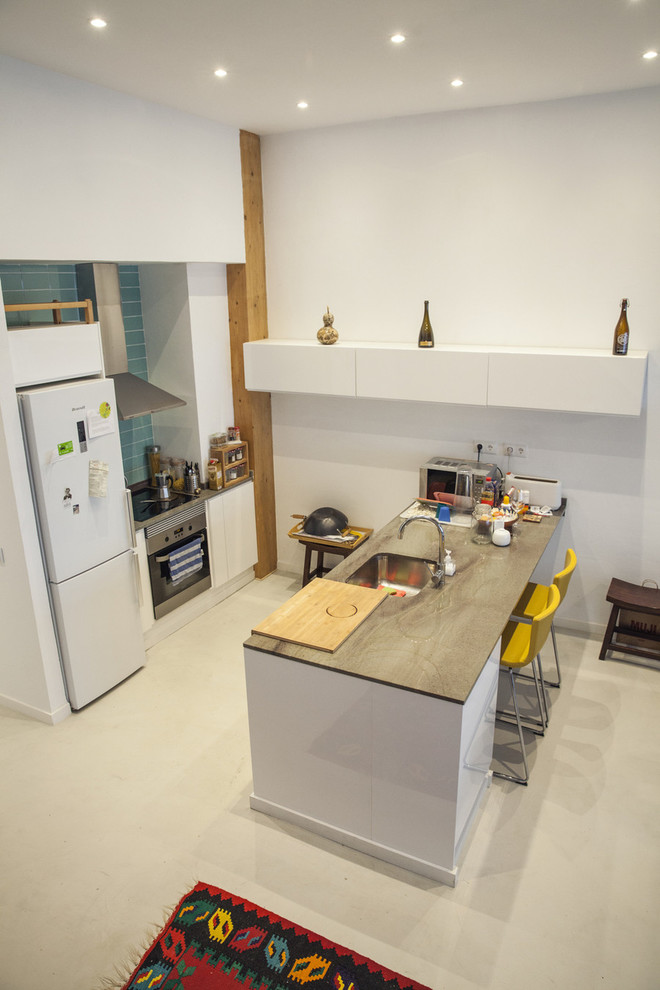 Ejemplo de cocina nórdica de tamaño medio abierta con armarios con paneles lisos, puertas de armario blancas y península