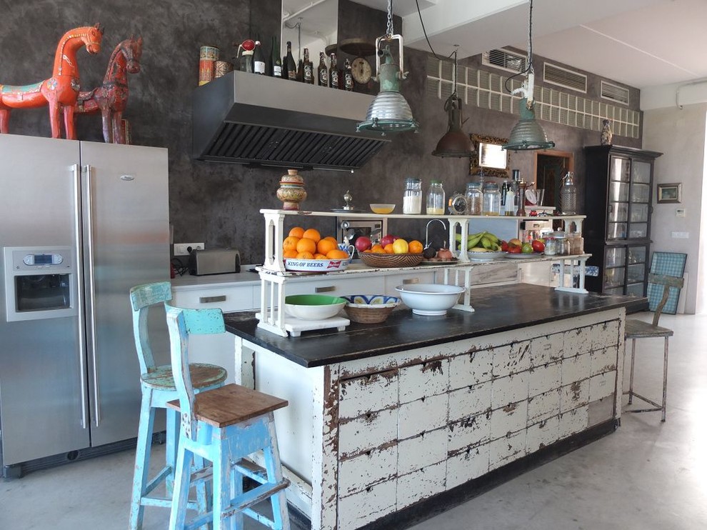 На фото: прямая кухня-гостиная среднего размера в стиле фьюжн с деревянной столешницей, серым фартуком, техникой из нержавеющей стали, бетонным полом, островом, плоскими фасадами и белыми фасадами