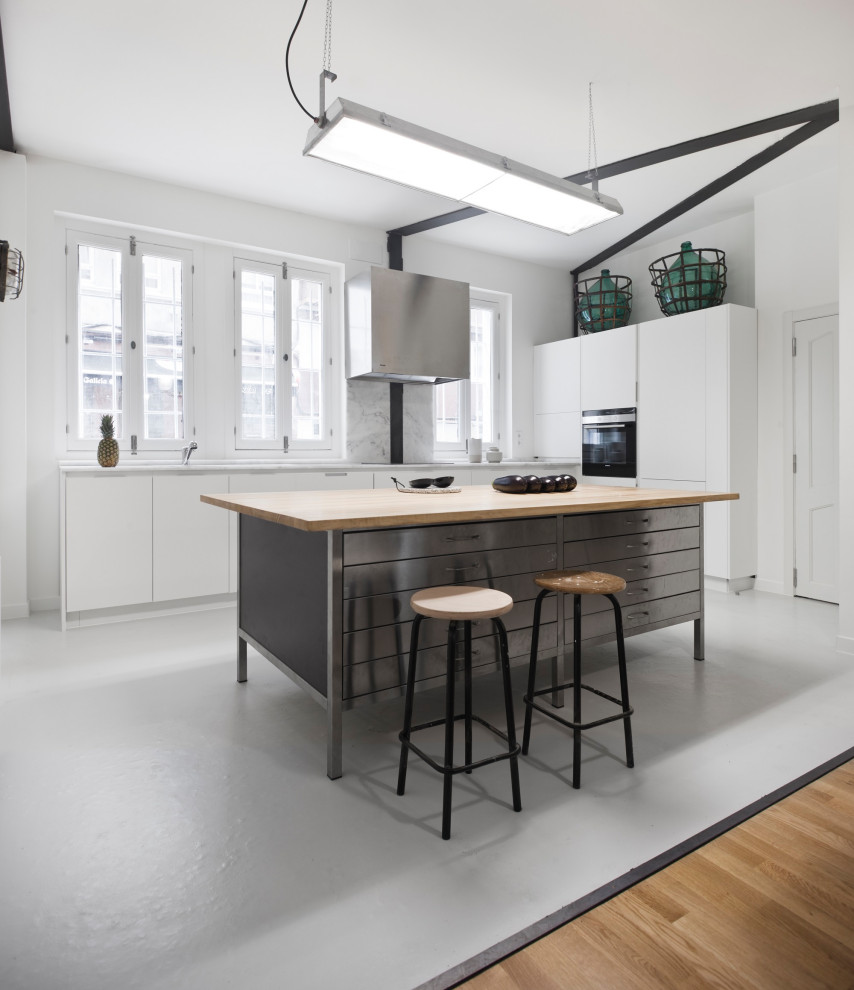 Immagine di una cucina design con ante lisce, ante bianche, elettrodomestici in acciaio inossidabile, pavimento bianco e top bianco