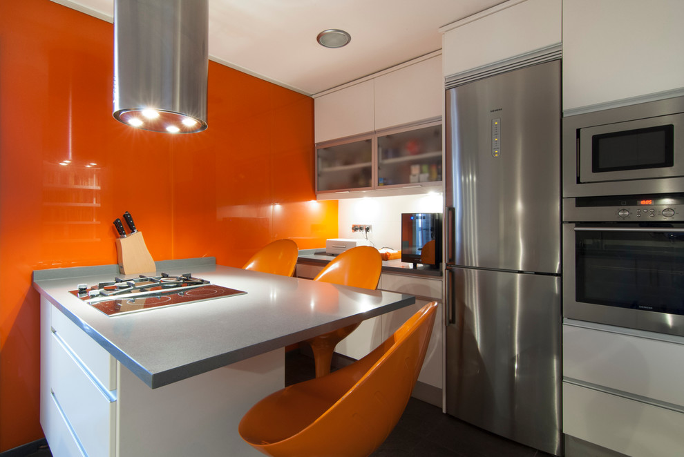 Photo of a medium sized contemporary single-wall open plan kitchen in Madrid with flat-panel cabinets, white cabinets, stainless steel appliances and a breakfast bar.