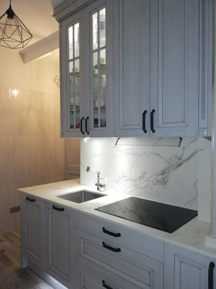 Inspiration for a medium sized classic l-shaped enclosed kitchen in Madrid with a submerged sink, raised-panel cabinets, light wood cabinets, engineered stone countertops, multi-coloured splashback, integrated appliances, porcelain flooring, no island, multi-coloured floors and multicoloured worktops.