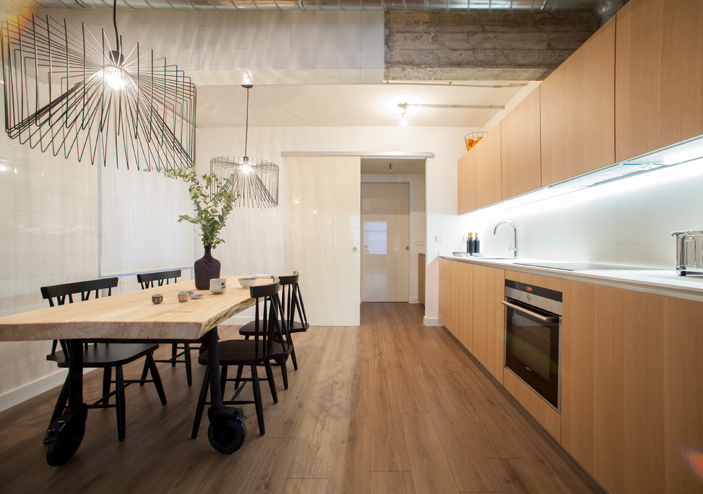 Aménagement d'une cuisine moderne en bois brun avec un placard à porte plane, une crédence blanche, un électroménager en acier inoxydable et un sol en bois brun.