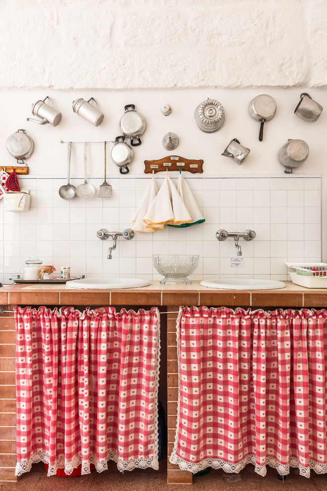 На фото: кухня в стиле кантри с накладной мойкой и белым фартуком с