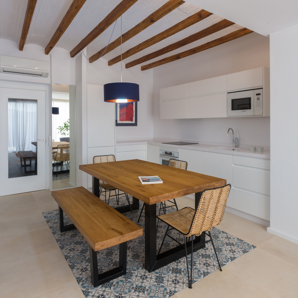 Пример оригинального дизайна: угловая кухня в средиземноморском стиле с обеденным столом, плоскими фасадами, белыми фасадами, бежевым полом, белой столешницей и красивой плиткой без острова