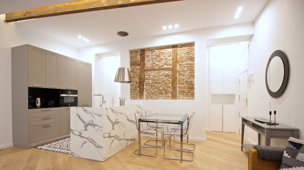 Offene, Zweizeilige Mediterrane Küche mit Schrankfronten im Shaker-Stil, grauen Schränken, Kücheninsel, weißer Arbeitsplatte, hellem Holzboden und beigem Boden in Madrid