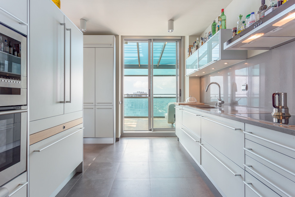 This is an example of a medium sized contemporary galley enclosed kitchen in Other with a double-bowl sink, flat-panel cabinets, white cabinets, grey splashback, no island, quartz worktops and ceramic flooring.