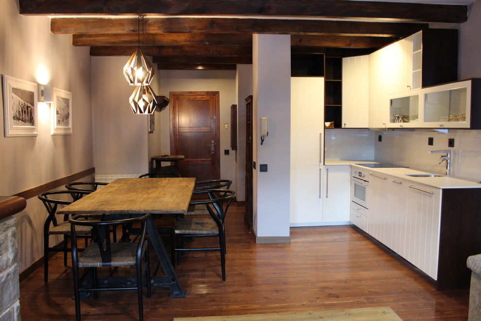 Idéer för ett litet rustikt kök, med en enkel diskho, luckor med upphöjd panel, vita skåp, vitt stänkskydd, vita vitvaror och mellanmörkt trägolv