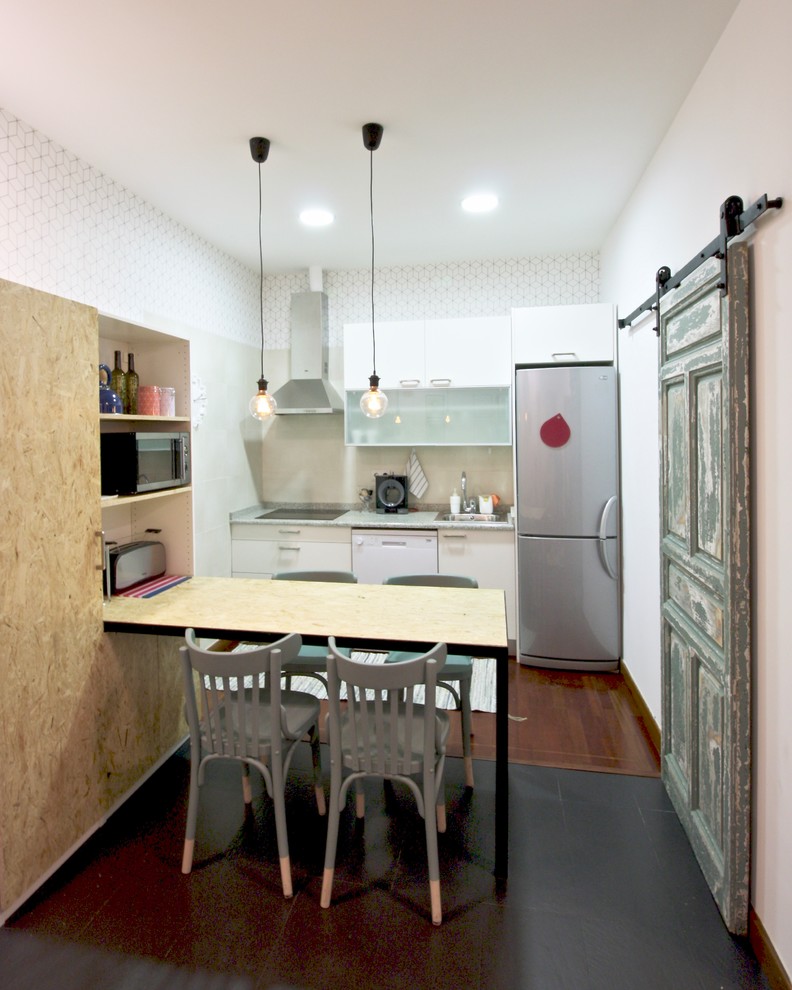 Einzeilige Skandinavische Wohnküche mit flächenbündigen Schrankfronten, weißen Schränken, Küchengeräten aus Edelstahl, Küchenrückwand in Weiß, dunklem Holzboden und grüner Arbeitsplatte in Madrid
