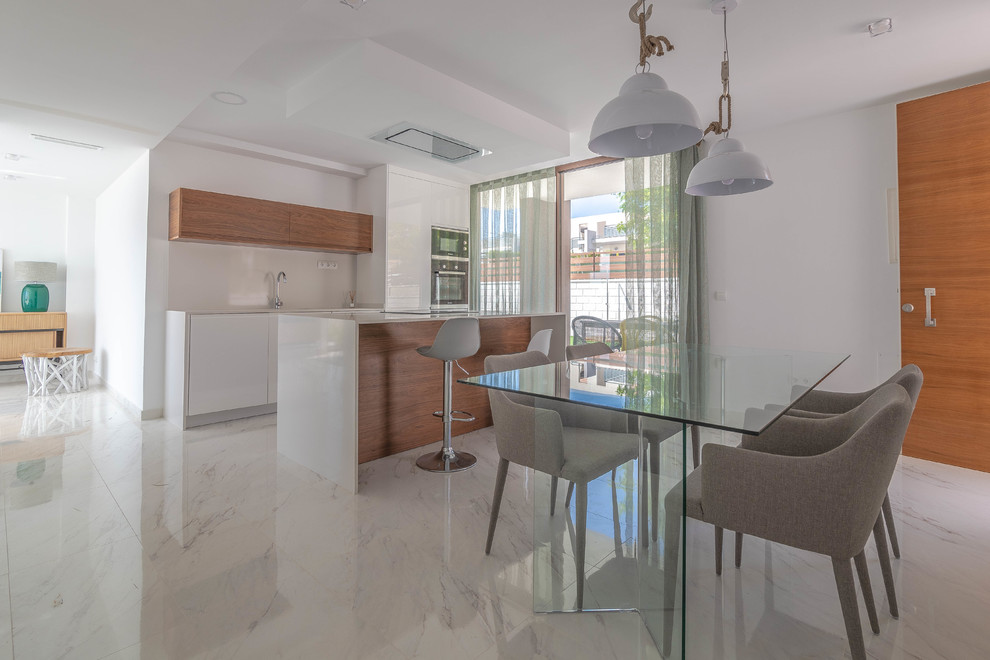 Modern kitchen in Alicante-Costa Blanca with medium wood cabinets, white splashback, stainless steel appliances, white floors and white worktops.
