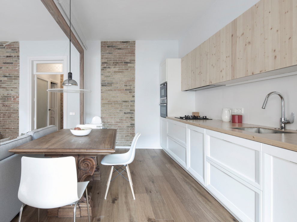 Modern inredning av ett beige linjärt beige kök och matrum, med luckor med infälld panel, vita skåp, vitt stänkskydd, mellanmörkt trägolv och brunt golv