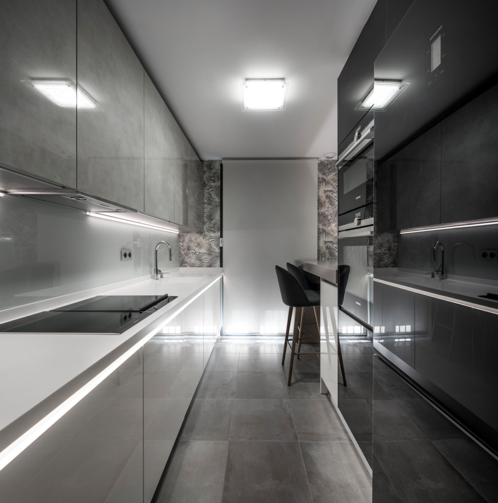 Foto di una piccola cucina lineare moderna chiusa con ante lisce, ante nere, top in superficie solida, paraspruzzi bianco, nessuna isola e top bianco