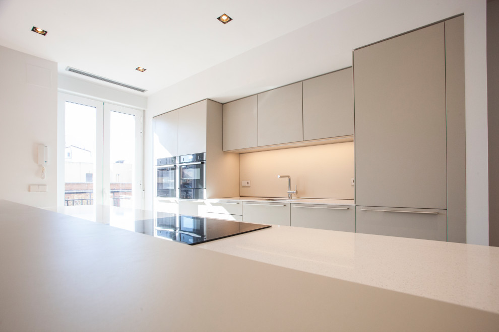 Design ideas for a large modern single-wall open plan kitchen in Madrid with a single-bowl sink, recessed-panel cabinets, beige cabinets, marble worktops, beige splashback, stone slab splashback, integrated appliances, porcelain flooring, an island, white floors and beige worktops.