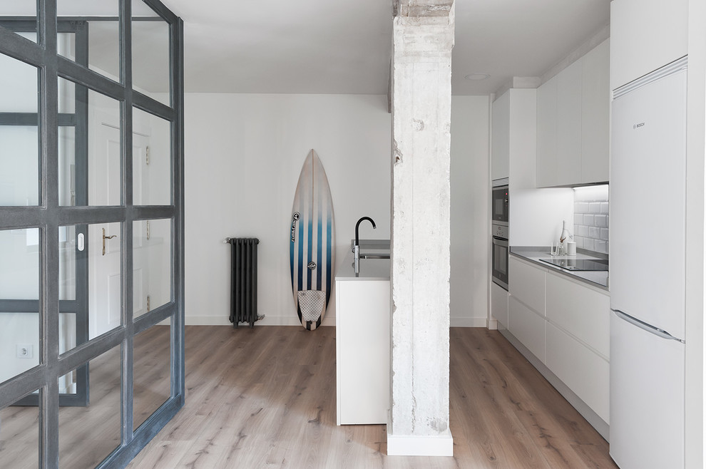 Idee per una cucina stile marinaro di medie dimensioni con ante lisce, ante bianche, pavimento in legno massello medio e penisola