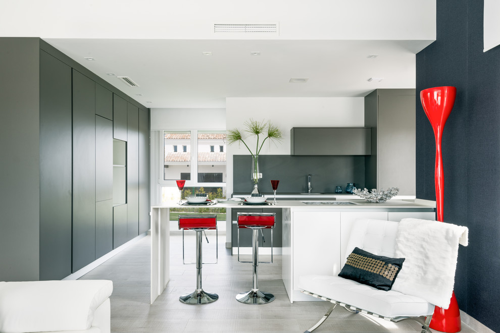 На фото: параллельная кухня-гостиная среднего размера в современном стиле с плоскими фасадами, полуостровом, одинарной мойкой, серыми фасадами и серым фартуком