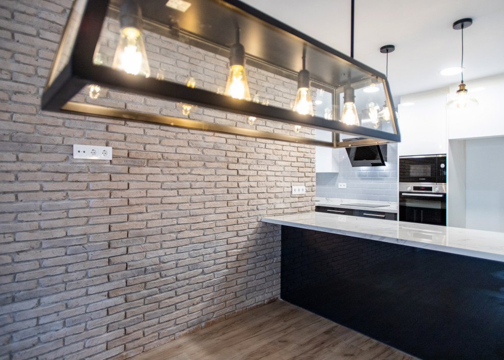 Example of a mid-sized trendy u-shaped open concept kitchen design in Barcelona with a single-bowl sink, black cabinets, white backsplash, ceramic backsplash, stainless steel appliances, no island and white countertops