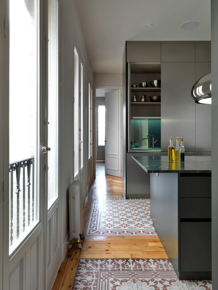 Idéer för att renovera ett mellanstort funkis linjärt kök med öppen planlösning, med släta luckor, grå skåp, marmorbänkskiva, klinkergolv i keramik, en köksö och flerfärgat golv