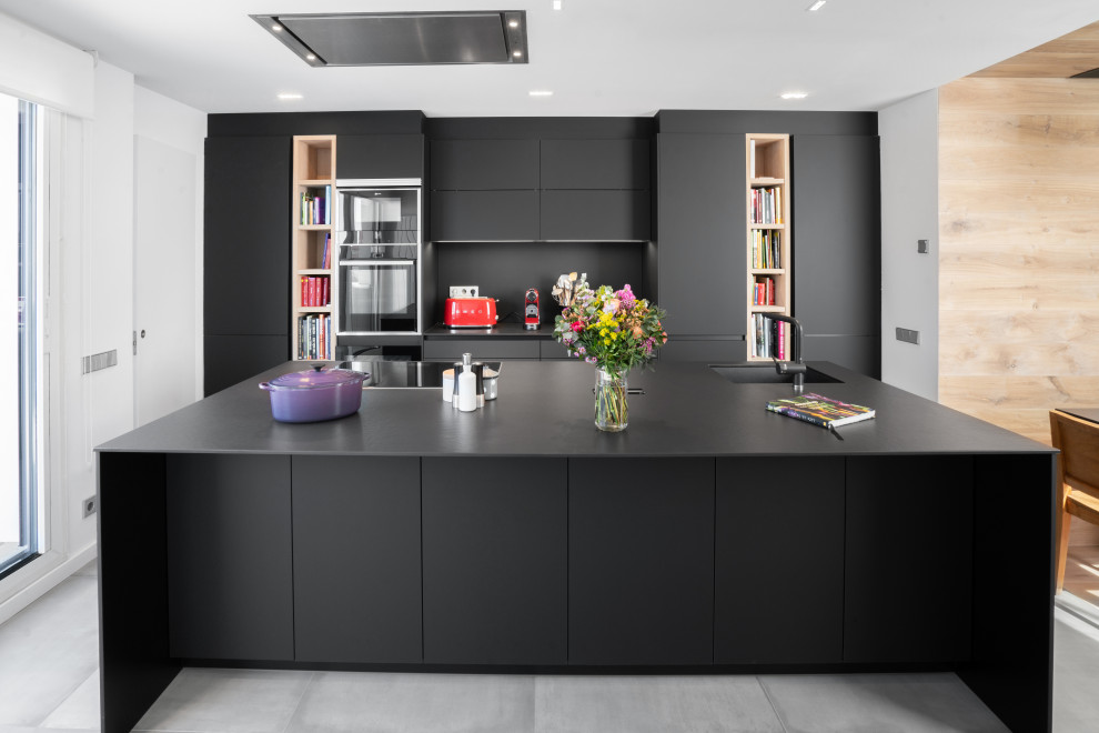 Idee per una grande cucina minimalista con ante lisce, ante nere, paraspruzzi nero, pavimento grigio e top nero