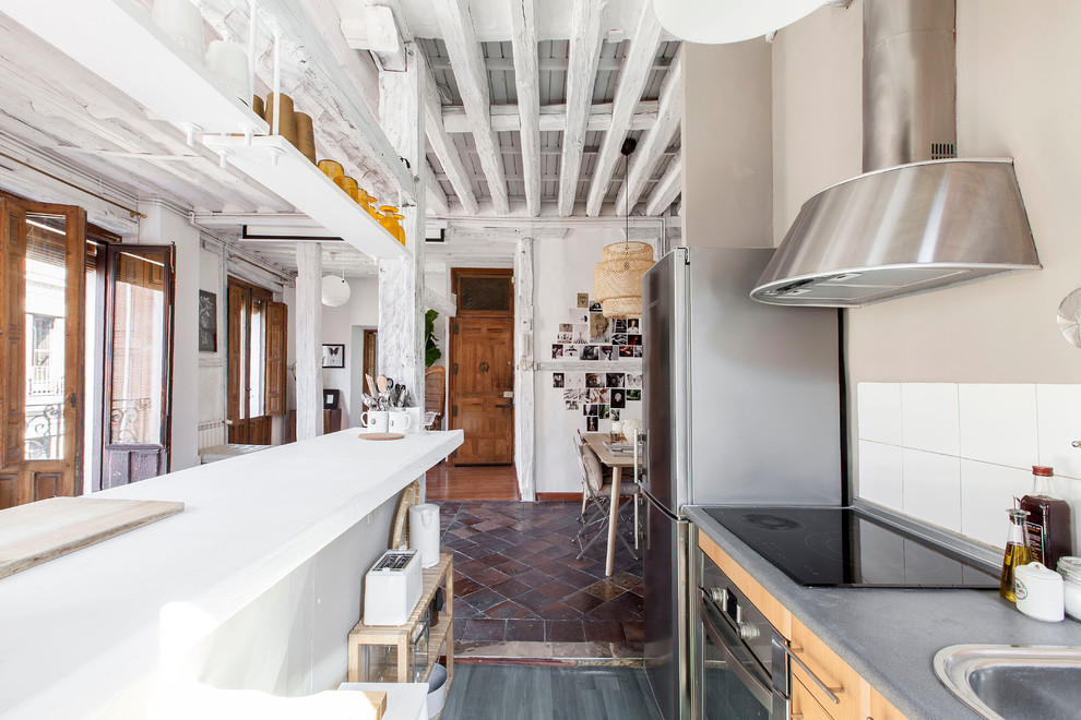 Foto de cocina lineal ecléctica de tamaño medio abierta con salpicadero blanco, salpicadero de azulejos de cerámica, electrodomésticos de acero inoxidable y una isla