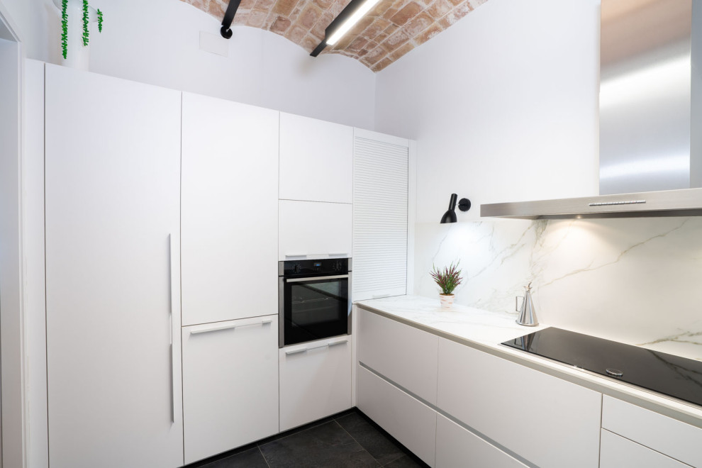 Inspiration för ett avskilt, litet funkis u-kök, med en nedsänkt diskho, vita skåp, svarta vitvaror, klinkergolv i porslin och grått golv
