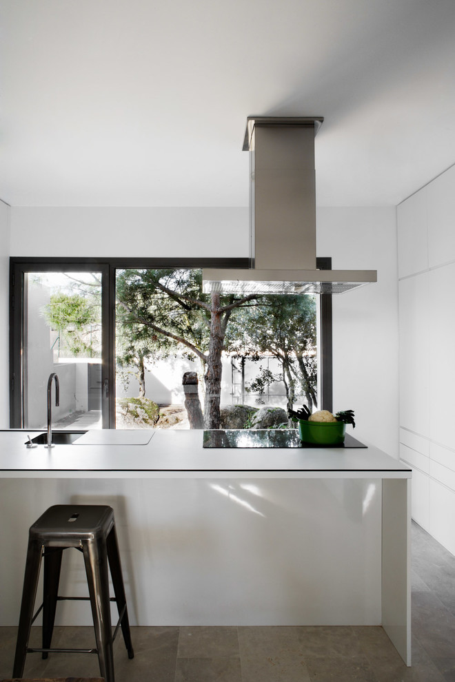 Immagine di un cucina con isola centrale design con pavimento in pietra calcarea