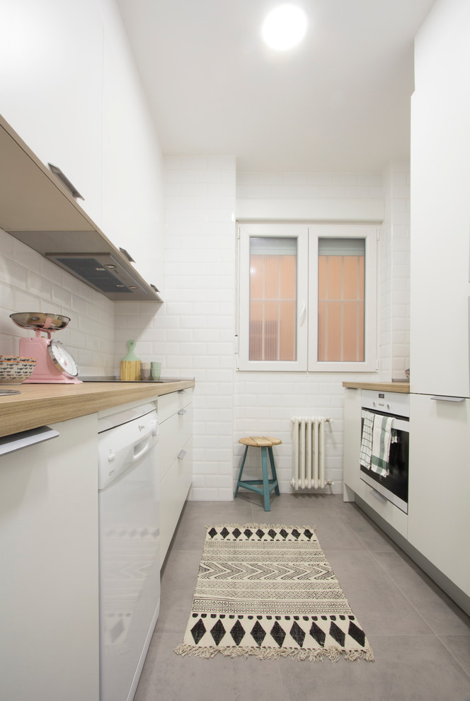 Design ideas for a small scandi single-wall enclosed kitchen in Madrid with a double-bowl sink, flat-panel cabinets, white cabinets, wood worktops, white appliances, porcelain flooring and no island.