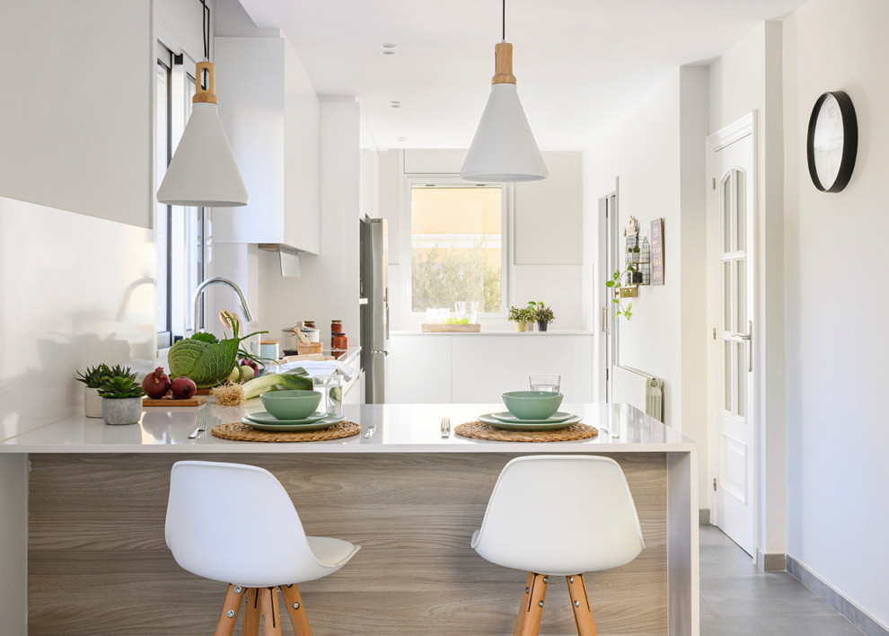 Large mediterranean single-wall enclosed kitchen in Other with a submerged sink, flat-panel cabinets, white cabinets, quartz worktops, white splashback, limestone splashback, stainless steel appliances, ceramic flooring, a breakfast bar, grey floors, white worktops and a drop ceiling.
