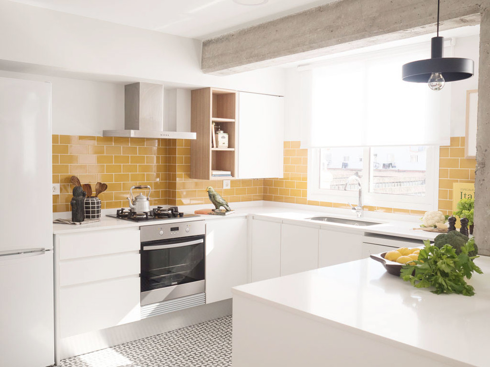Example of a trendy u-shaped multicolored floor kitchen design in Valencia with an undermount sink, flat-panel cabinets, white cabinets, yellow backsplash, subway tile backsplash, stainless steel appliances, a peninsula and white countertops