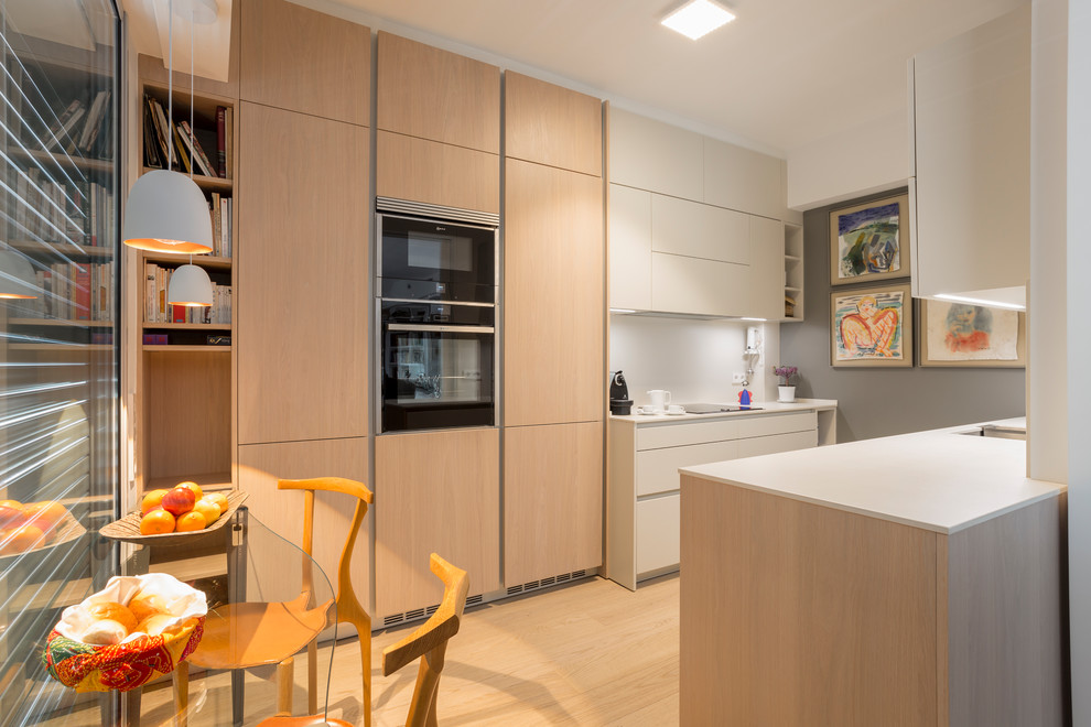 Foto de cocina contemporánea de tamaño medio sin isla con electrodomésticos de acero inoxidable, suelo de madera en tonos medios y suelo marrón