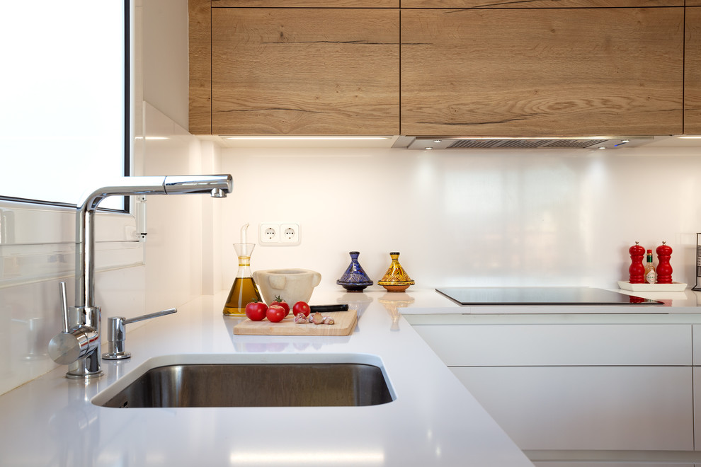 Idéer för ett mellanstort modernt vit kök, med en enkel diskho, skåp i mellenmörkt trä, vitt stänkskydd, rostfria vitvaror, mellanmörkt trägolv och brunt golv