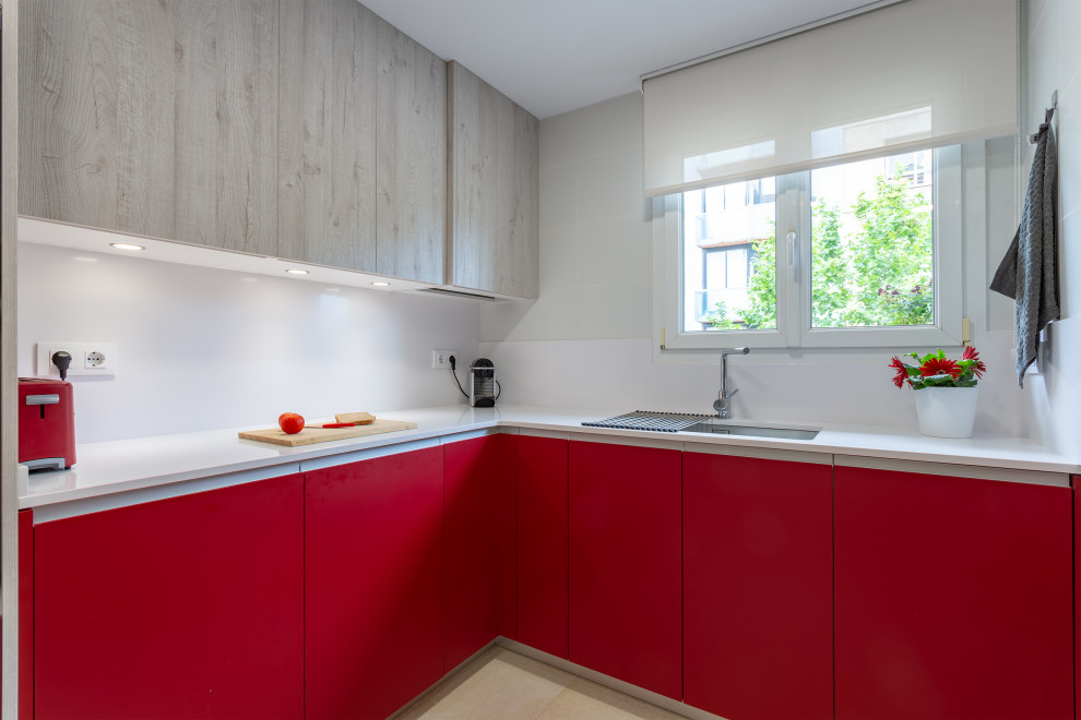 Exempel på ett mellanstort modernt vit vitt kök, med en dubbel diskho, släta luckor, röda skåp, vitt stänkskydd, rostfria vitvaror, klinkergolv i keramik, en halv köksö och beiget golv