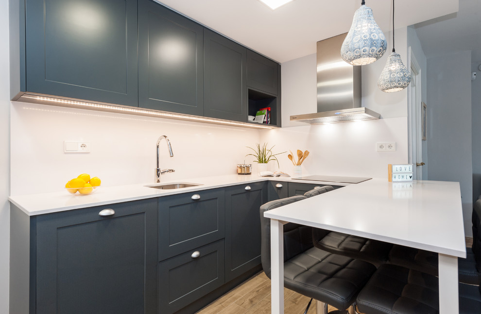 Open concept kitchen - mid-sized transitional u-shaped porcelain tile and brown floor open concept kitchen idea in Barcelona with a single-bowl sink, blue cabinets, quartz countertops, white backsplash, a peninsula, white countertops, shaker cabinets and paneled appliances