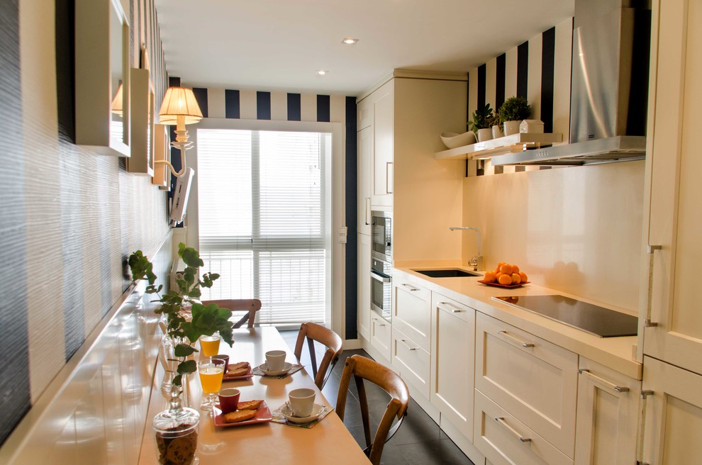 Klassisk inredning av ett mellanstort linjärt kök och matrum, med en undermonterad diskho, luckor med infälld panel, vita skåp, bänkskiva i kvarts, vitt stänkskydd, rostfria vitvaror och klinkergolv i keramik