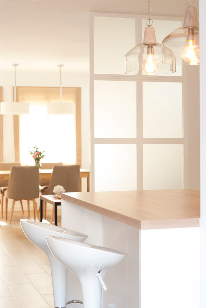 Foto de cocina comedor lineal contemporánea de tamaño medio con armarios con paneles lisos, puertas de armario blancas, encimera de madera, salpicadero blanco, electrodomésticos de acero inoxidable y una isla