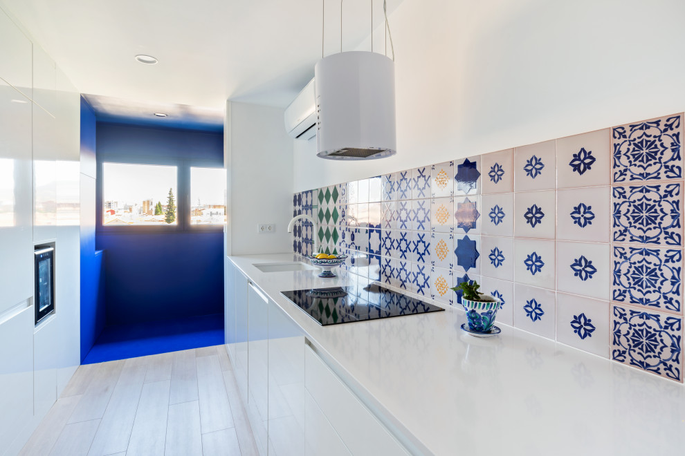 Inspiration for a medium sized mediterranean single-wall open plan kitchen in Other with a submerged sink, flat-panel cabinets, white cabinets, engineered stone countertops, white appliances, laminate floors and white worktops.