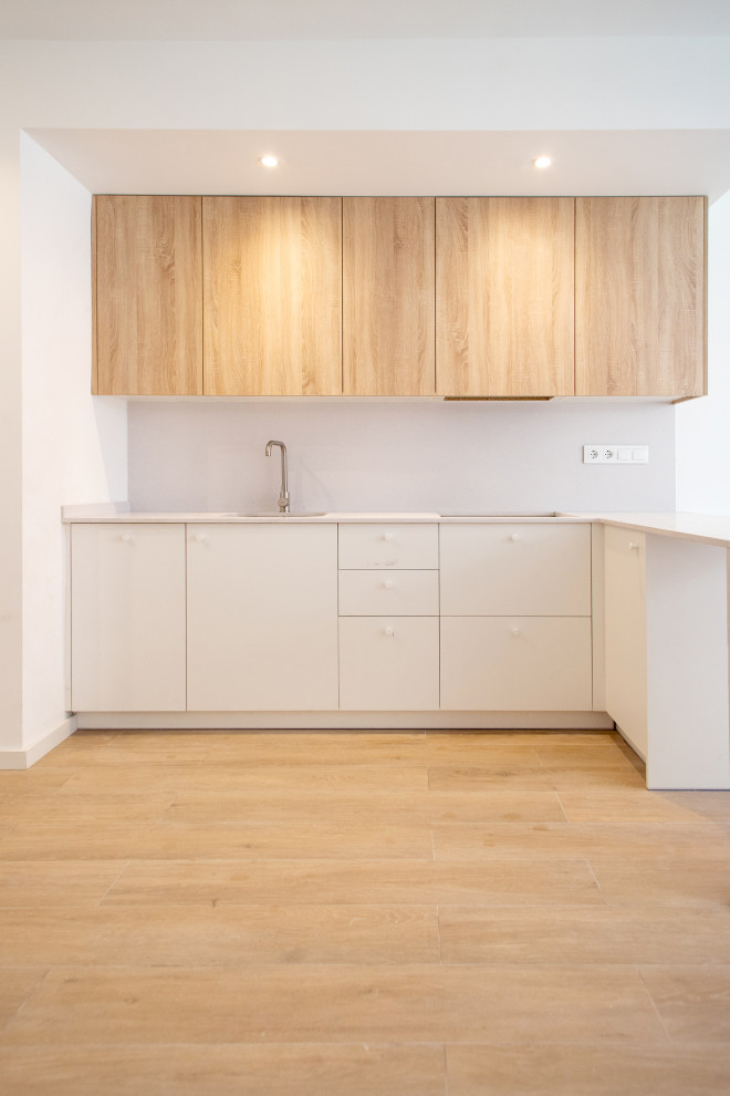 Idéer för att renovera ett mellanstort funkis vit vitt kök, med en enkel diskho, släta luckor, skåp i mellenmörkt trä, vita vitvaror, mellanmörkt trägolv och brunt golv