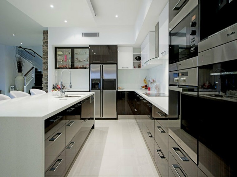 Große Moderne Küche in L-Form mit flächenbündigen Schrankfronten, schwarzen Schränken, Küchengeräten aus Edelstahl und Kücheninsel in Madrid