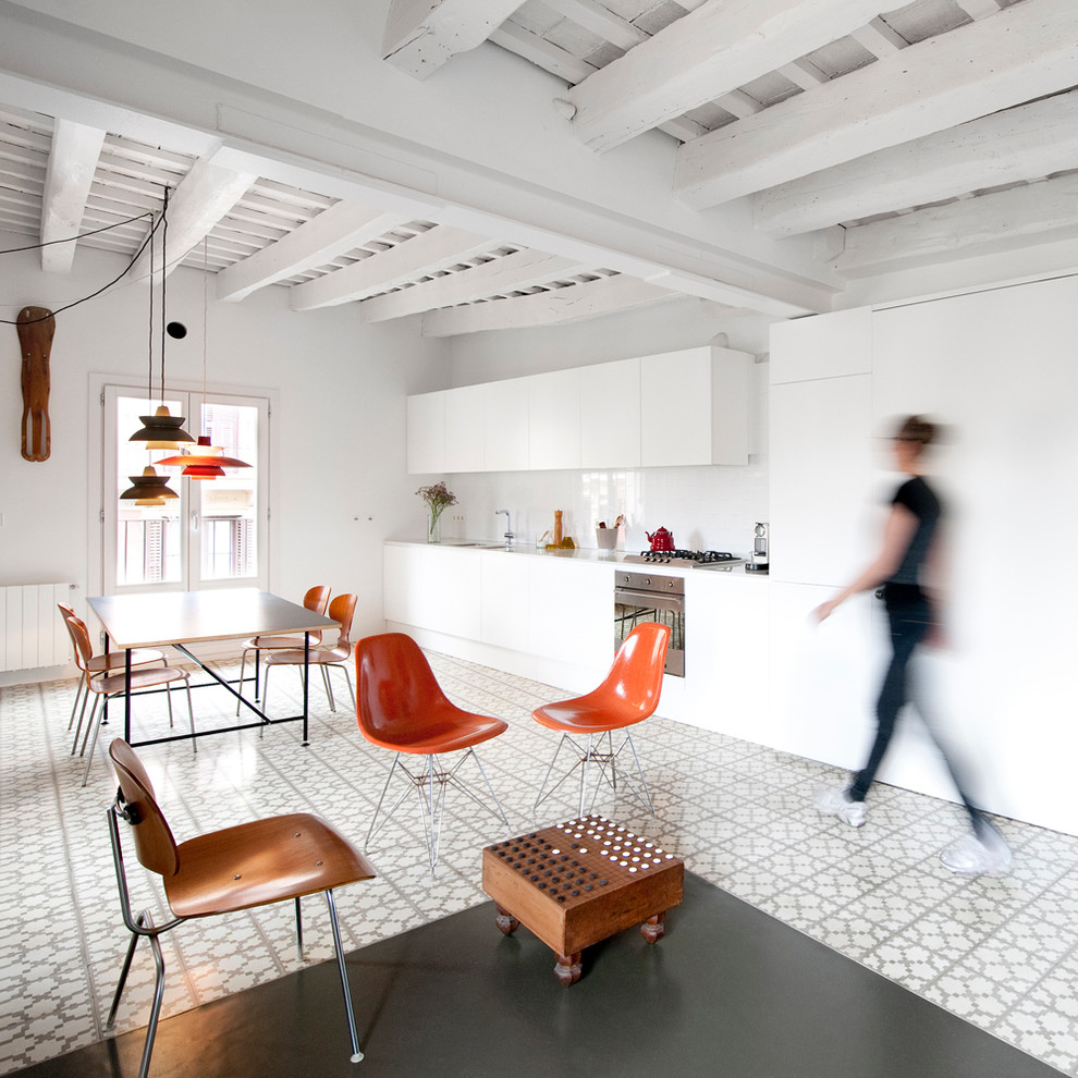 バルセロナにある高級な広い北欧スタイルのおしゃれなキッチン (フラットパネル扉のキャビネット、白いキャビネット、白いキッチンパネル、セラミックタイルの床、アイランドなし、ダブルシンク、シルバーの調理設備) の写真
