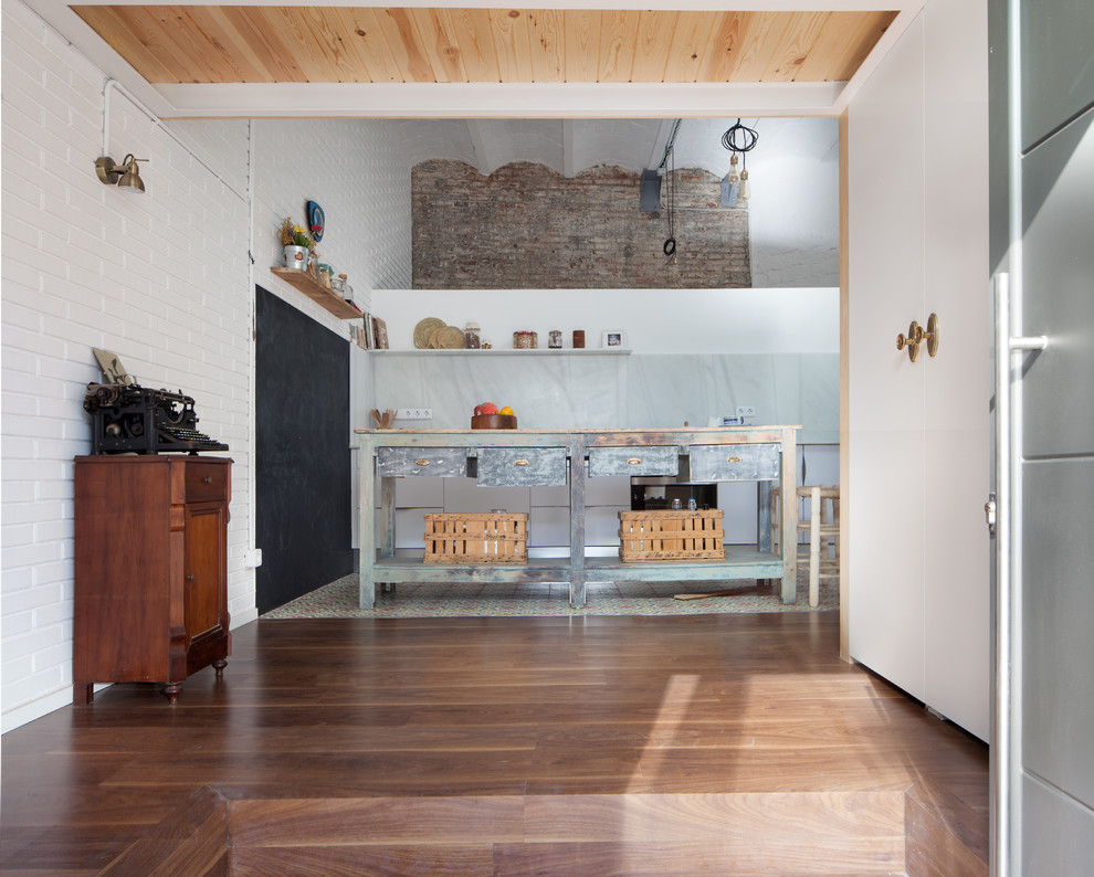 Imagen de cocina lineal industrial de tamaño medio abierta con armarios con paneles lisos, puertas de armario blancas y una isla