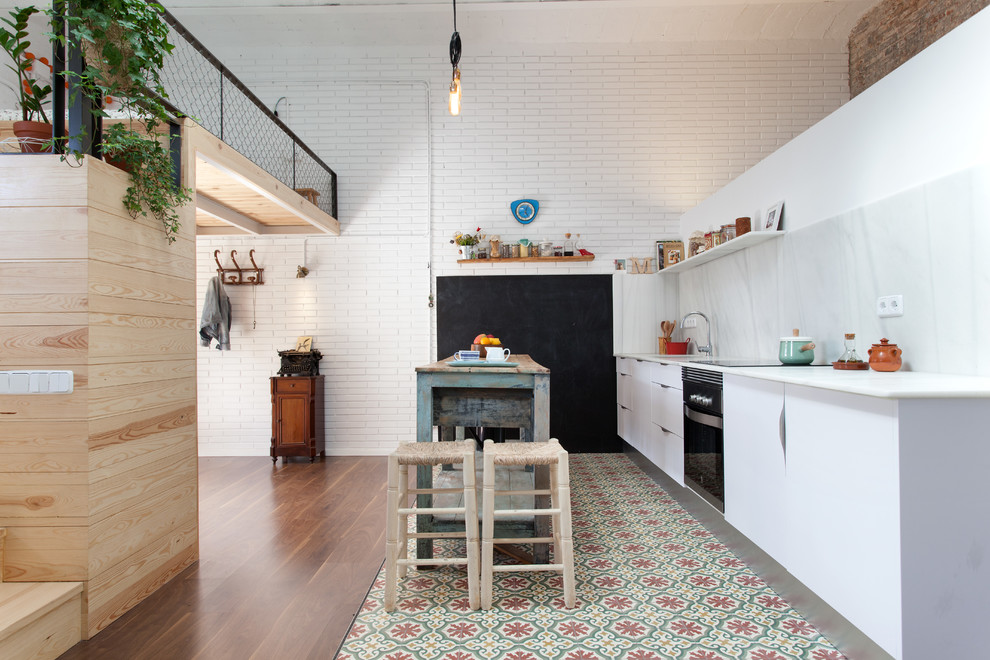 バルセロナにある広いインダストリアルスタイルのおしゃれなキッチン (フラットパネル扉のキャビネット、白いキャビネット、白いキッチンパネル、石スラブのキッチンパネル、黒い調理設備) の写真