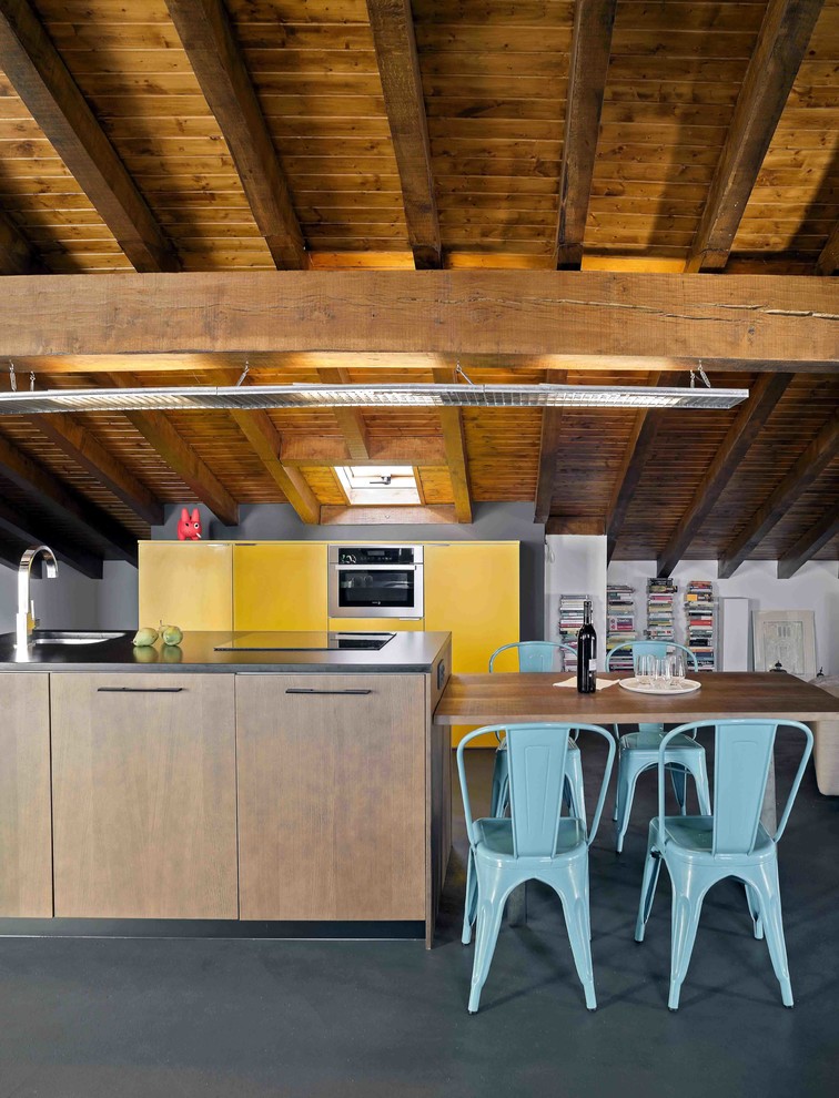 Foto di una grande cucina design con ante lisce, pavimento nero e ante gialle