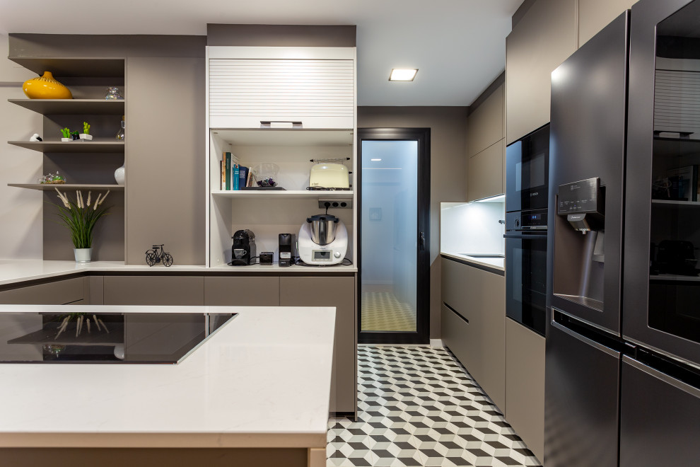 Свежая идея для дизайна: п-образная кухня среднего размера в современном стиле с плоскими фасадами, серыми фасадами, белым фартуком, черной техникой, полуостровом, разноцветным полом и белой столешницей - отличное фото интерьера