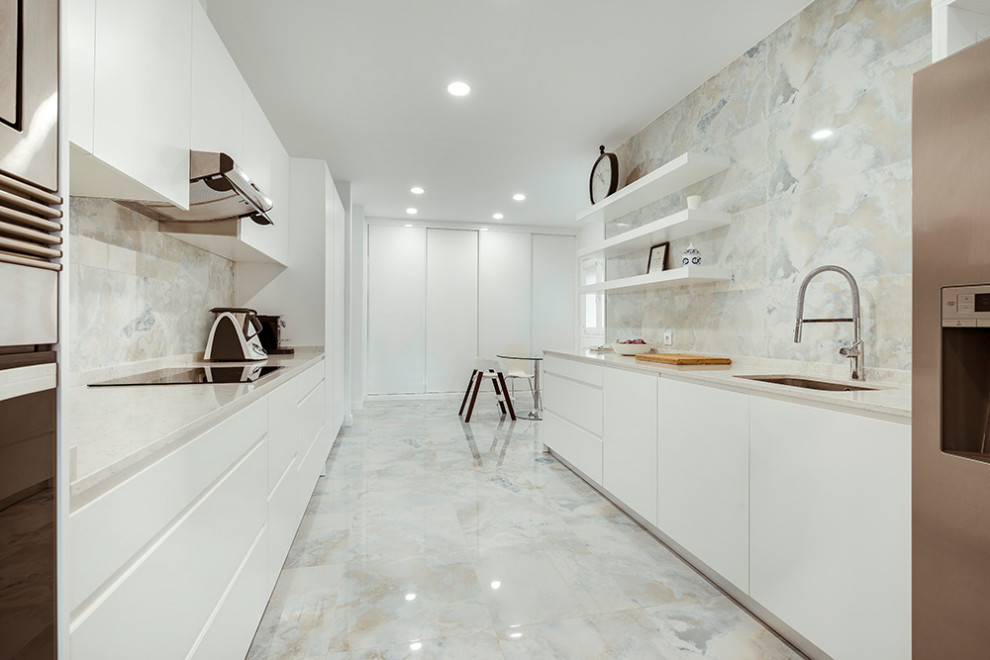 Foto på ett funkis beige kök, med en enkel diskho, släta luckor, vita skåp, bänkskiva i kvarts, grått stänkskydd, stänkskydd i marmor, rostfria vitvaror, marmorgolv och blått golv