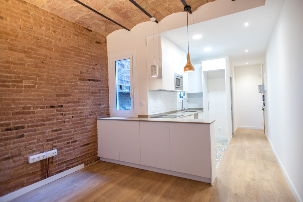 Photo of a medium sized contemporary u-shaped open plan kitchen in Barcelona with a single-bowl sink, flat-panel cabinets, white cabinets, white splashback, ceramic splashback, stainless steel appliances, ceramic flooring, no island, multi-coloured floors and beige worktops.